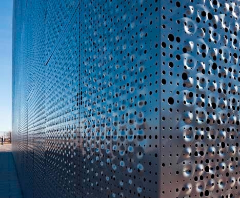How do the strength and rigidity of perforated metals affect their applications in construction and mechanical manufacturing?